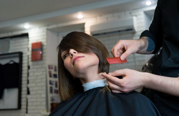 hairdresser combs the model before cutting