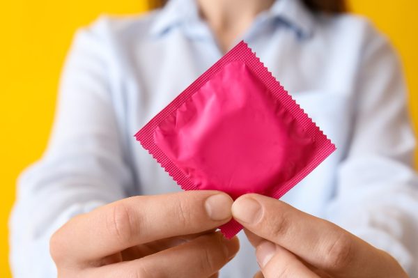 Woman with condom in package, closeup