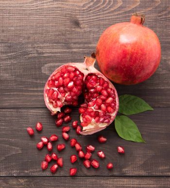 Ripe pomegranate fruit on wooden vintage background