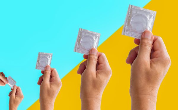foil pack of condom in male hand isolated on colorful background