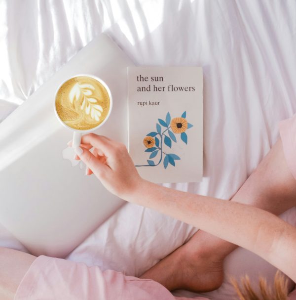 βιβλίο ποίησης στο κρεβάτι με καφέ
