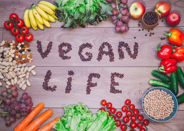 Go vegan concept green organic vegetables & bean on wood background.