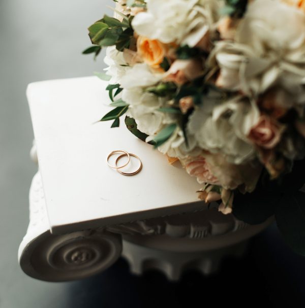 wedding rings and bridal bouquet close up top view