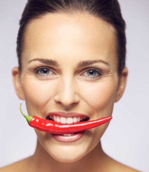 Beauty with hot pepper in her mouth