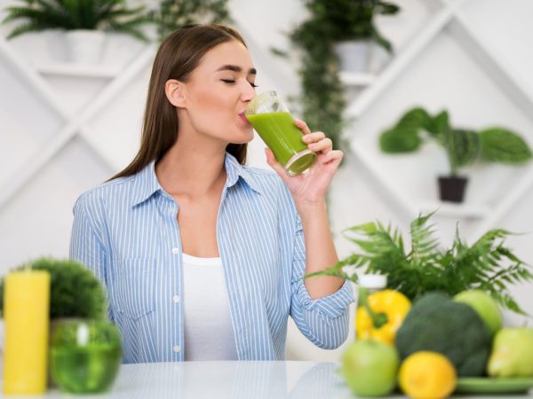Woman drinking freshly squeezed detox drink, copy space
